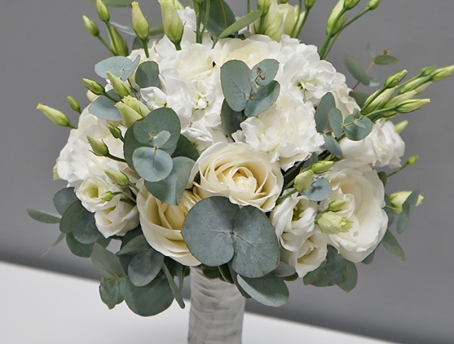 Bridal bouquet of white spray rose, white rose, eustoma, white dianthus, mathiola, hypericum, and eucalyptus photo